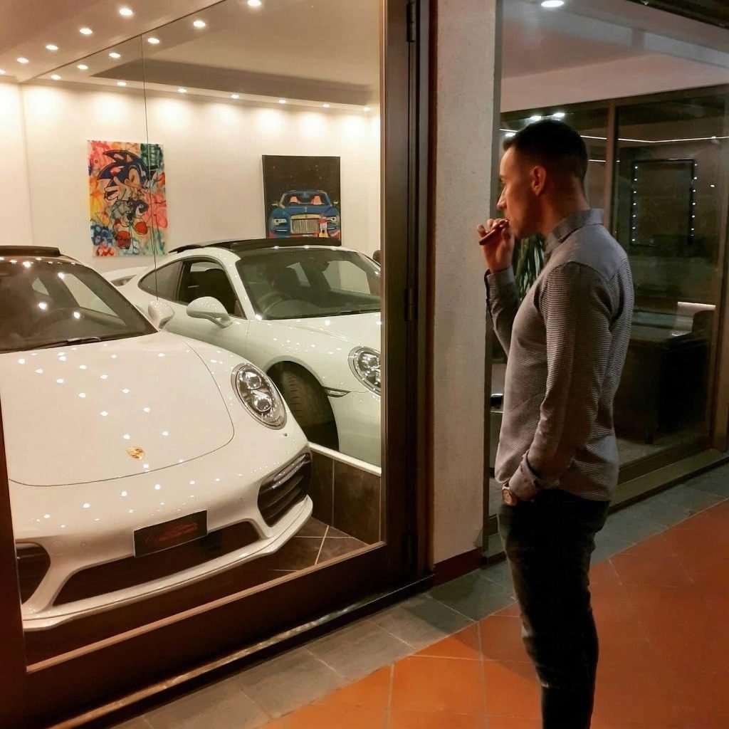 Imprenditore davanti a due auto sportive di lusso